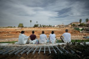 Voluntarios en su descanso mirando el canal. A la altura del puente de la estación, Paiporta